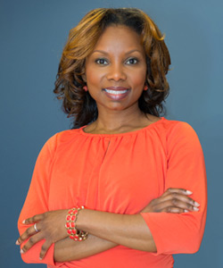 A woman in orange dress standing with a blue background